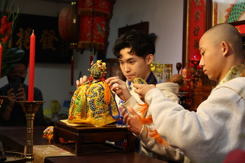 祖師爺冬季換袍大典由國立臺灣戲曲學院學生秦朗(左)與余銘賢(右)為祖師爺換袍