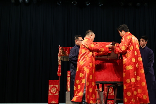 李揚校長(右)與張德天團長(左)將喜神(大師哥)放入箱內