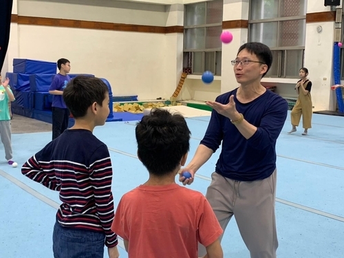 國立臺灣戲曲學院「特技雜耍體驗營」，專任講師陳儒文指導「雜耍球拋接」，透過遊戲式教學暖身。(戲曲學院提供)